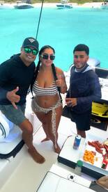 A lively group enjoys a fun day on the boat, showcasing snacks and drinks while celebrating together in the beautiful turquoise waters.