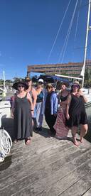 A joyful group of friends poses together at the dock, ready for a fun day on the water — perfect for celebrations and memorable outings.