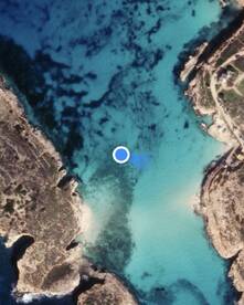 Aerial view of a coastal area with clear turquoise waters and rocky shorelines, but the image lacks clarity and detail.