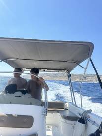 A family enjoys a day on the water, cruising on a boat with beautiful scenery in the background — perfect for memorable outings and adventures.