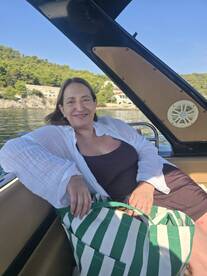A woman relaxes on a boat, enjoying a sunny day by the water — a perfect moment for leisure and tranquility on the sea.
