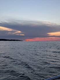 A serene sunset view over the water, showcasing the tranquil beauty of the sea — perfect for evening boat cruises.