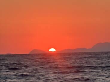 A stunning sunset over the ocean, casting vibrant hues across the sky and water — a perfect backdrop for evening boat cruises.