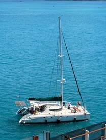 A lively group enjoys a sunny day aboard a catamaran, showcasing the perfect setting for a fun day on the water.