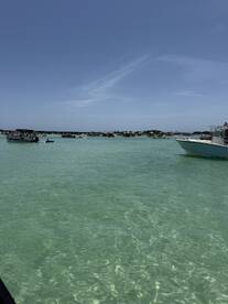 A vibrant scene of boats anchored in crystal-clear turquoise waters, showcasing a lively atmosphere perfect for a day of fun on the water.