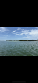 A scenic view of water and shoreline under a clear sky, but the image lacks clarity and detail.