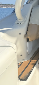 Interior view of a boat's seating area, showcasing the helm and upholstery details, ideal for comfortable cruising.