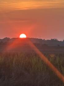 A stunning sunset casts a warm glow over the horizon, creating a picturesque scene perfect for evening boat trips or relaxing moments on the water.
