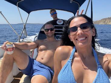 A cheerful group enjoys a sunny day on the boat, capturing fun moments and relaxation on the water.