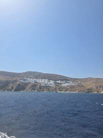 A stunning view of a coastal hillside with white buildings, showcasing the beautiful scenery of the island — perfect for travelers seeking picturesque destinations.