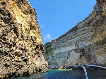 A stunning view of dramatic rock formations along the coastline, showcasing the natural beauty of the area — perfect for scenic boat tours.