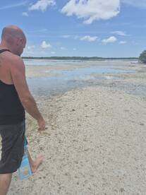 A man explores a sandy beach area, showcasing the beauty of nature and the joy of outdoor adventures.