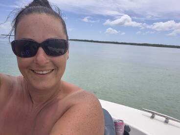 A joyful selfie on a boat with clear waters in the background, capturing a moment of fun and relaxation on the water.