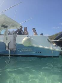 A group of friends enjoys a sunny day on a Boston Whaler, showcasing the fun and camaraderie of a boating adventure in clear waters.