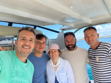 A cheerful group of friends poses for a selfie aboard a boat, enjoying their time on the water — perfect for memorable outings and adventures.