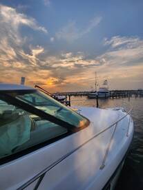 A stunning side view of a yacht docked at sunset, showcasing the serene marina atmosphere and beautiful sky.