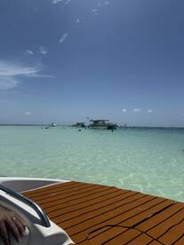 A vibrant scene at a sandbar with guests enjoying the clear waters, perfect for swimming and relaxation under the sun.
