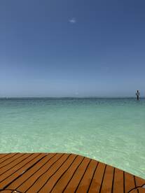 A view of clear turquoise waters and a wooden deck, but the image lacks clarity and identifiable subjects.