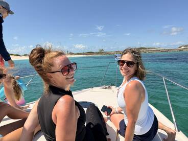 A joyful group of friends enjoys a sunny day on the boat, capturing smiles and laughter against a stunning ocean backdrop — perfect for memorable outings and adventures.