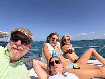 A fun group enjoys a sunny day on a yacht, lounging and soaking up the sun — perfect for a relaxing getaway on the water.