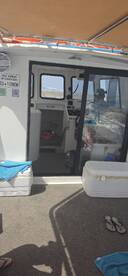 Interior view of a boat's helm and cabin area, showcasing the console and seating arrangements — ideal for navigation and comfort while on the water.