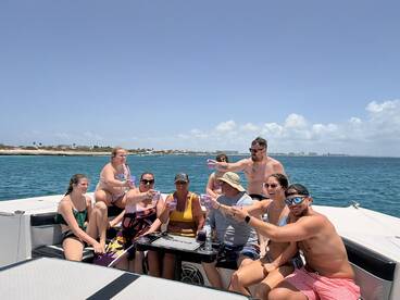 A lively group enjoys drinks and laughter aboard a pontoon boat, capturing the essence of a fun-filled day on the water.
