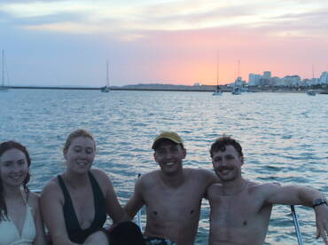 A cheerful group enjoys a sunset moment on the water, capturing the essence of a perfect boating experience with friends.