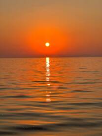 A serene sunset over calm waters, creating a picturesque reflection — perfect for capturing the beauty of nature.