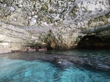 A stunning view of a natural cave with crystal-clear waters, showcasing the beauty of underwater scenery — perfect for eco-tours and exploration.
