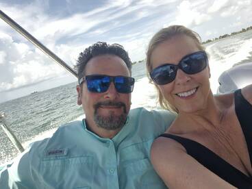 A couple enjoys a sunny day on the water, capturing a joyful selfie while boating — perfect for romantic getaways or fun adventures.