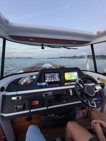 A view of the helm inside a boat, showcasing the modern console and navigation equipment, perfect for a day on the water.
