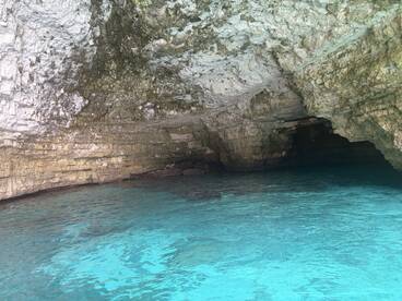 A stunning view of a natural cave with turquoise waters, perfect for exploring hidden gems during a boating adventure.