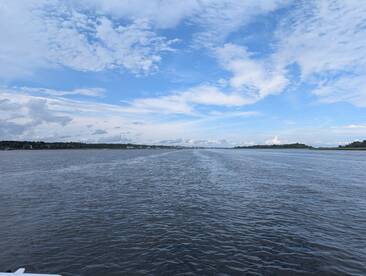 A serene view of the waterway under a vast sky, showcasing the natural beauty of the landscape — perfect for those seeking peaceful boating experiences.