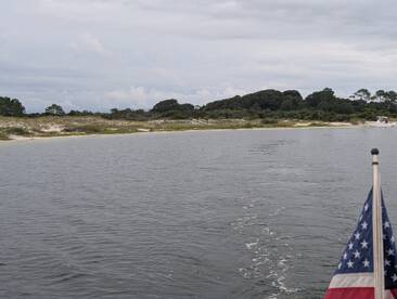 A serene view of a coastline with gentle waves and lush greenery, perfect for showcasing the beauty of a boating adventure.