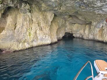 A stunning view of a coastal cave with crystal-clear waters, perfect for exploring hidden gems while boating.
