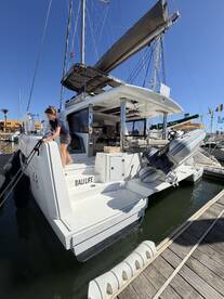 A sleek catamaran named 'Bali Life' docked at the marina, showcasing its modern design and spacious rear deck — perfect for luxury sailing experiences.