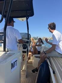 A lively group enjoys their time aboard a boat, engaging in conversation and laughter, perfect for a fun day on the water.