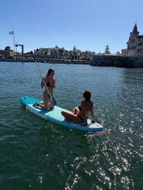 Two friends enjoy paddleboarding on a sunny day, creating a perfect backdrop for fun water activities and memorable experiences.