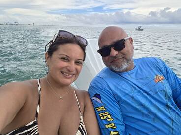 A happy couple enjoys a day on the water, capturing a joyful moment while boating in the ocean.