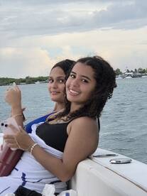 Two friends enjoy a sunny day on the boat, smiling and relaxing by the water — perfect for memorable outings with friends.