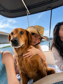 A joyful moment on a boat with a woman and her golden retriever, capturing the essence of fun and companionship on the water.