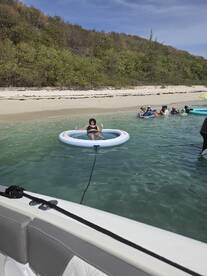 A fun day at the beach with friends, featuring a group enjoying the water and relaxing on floating mats — perfect for summer outings.