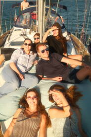 A lively group enjoys a sunny day on a sailboat, lounging and celebrating together — perfect for memorable sailing adventures.
