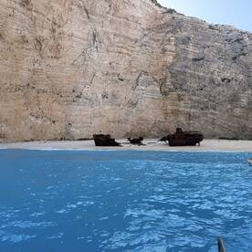 A stunning view of shipwrecks resting on a sandy beach, framed by towering cliffs — a captivating landscape perfect for exploring the history of maritime adventures.