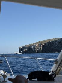 A scenic view from a boat showcasing a stunning coastline and rock formations, perfect for exploring beautiful islands and enjoying the open water.