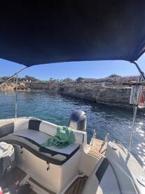 A cozy interior view of a boat showcasing comfortable seating and a well-equipped helm, perfect for a day out on the water.