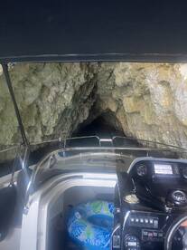 Inside view of a boat's helm area, showcasing the dashboard and a colorful inflatable float, perfect for exploring hidden caves and coastal adventures.
