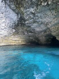 A stunning view of a cave with crystal-clear turquoise waters, showcasing the natural beauty of the underwater landscape — perfect for eco tours and exploration.