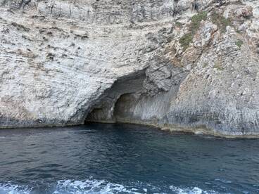 A stunning view of a coastal cave, showcasing the natural beauty of the shoreline — perfect for exploring unique geological formations while boating.