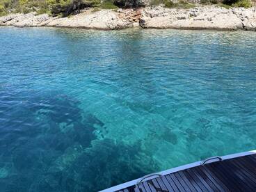 A serene view of clear turquoise waters and rocky shoreline, ideal for exploring coastal landscapes.